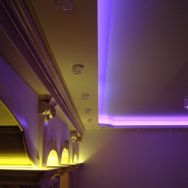Светодиодная подсветка в зале, установленная за карнизом и в обрамлении колонн